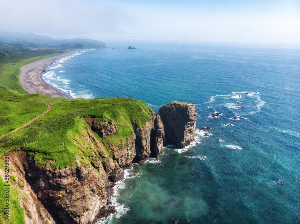 Green beautiful rocks of Kamchatka against the background of the bright blue sky.