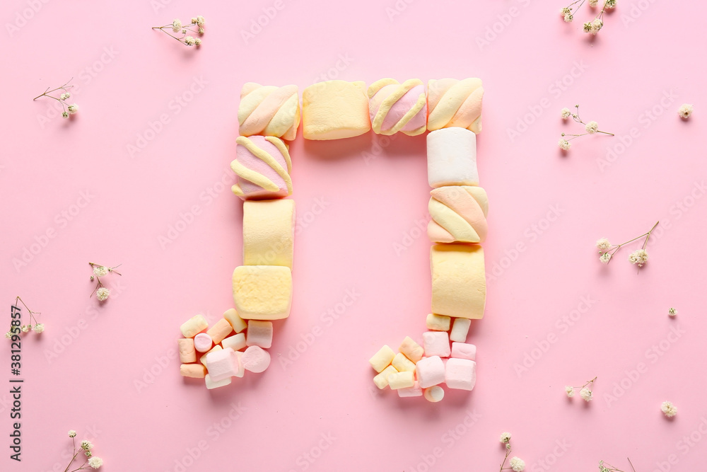 Music note made of marshmallows on color background