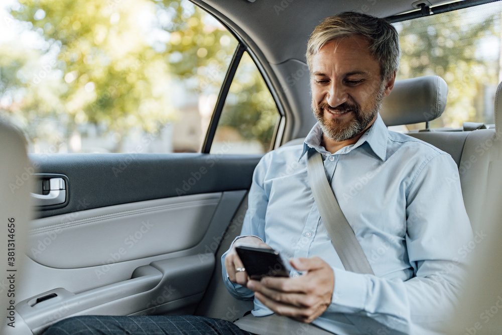 Man chatting with someone over the phone, in the car.