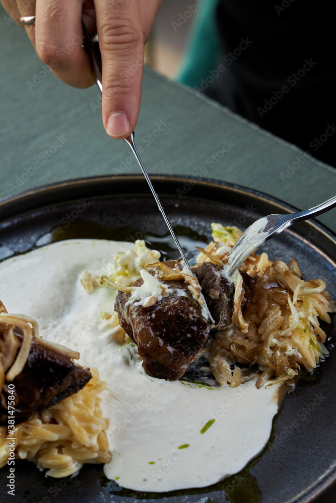 Person holds a fork in his food