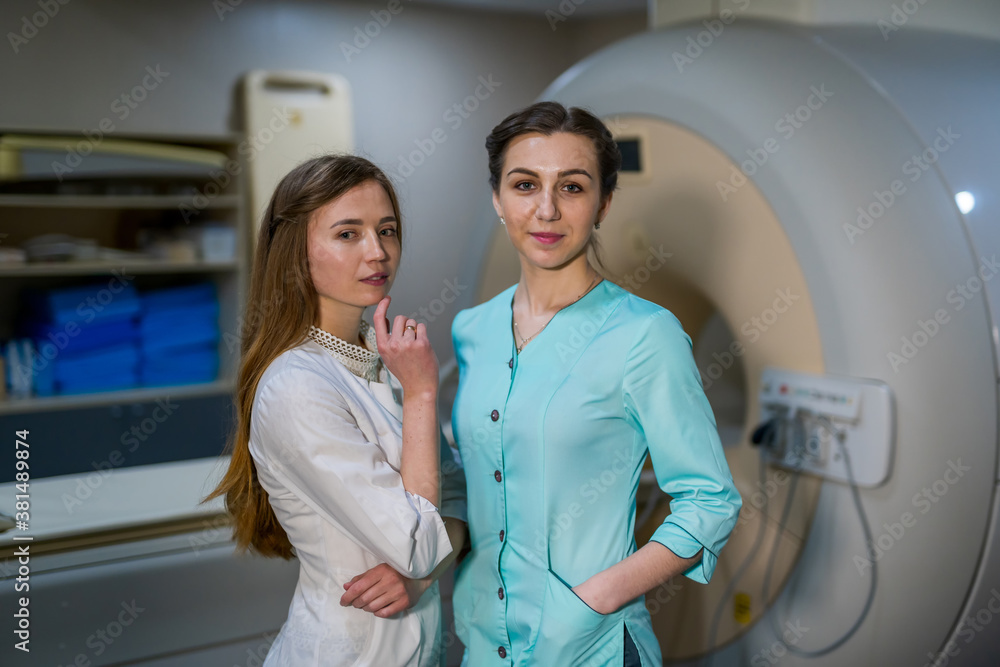 Two professional radiologist. Female doctors are posing near MRI or CT machine. Neurology and neuros