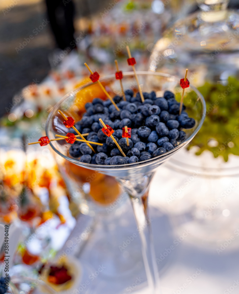 Blueberries in glass. Wooden pi?ks in berries. Catering on wedding. Wedding banquet table. Sweet tab