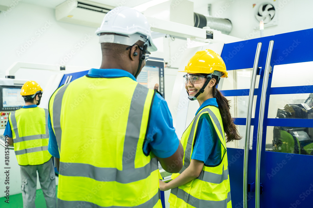 African Engineer Man talking to female worker in operating room.