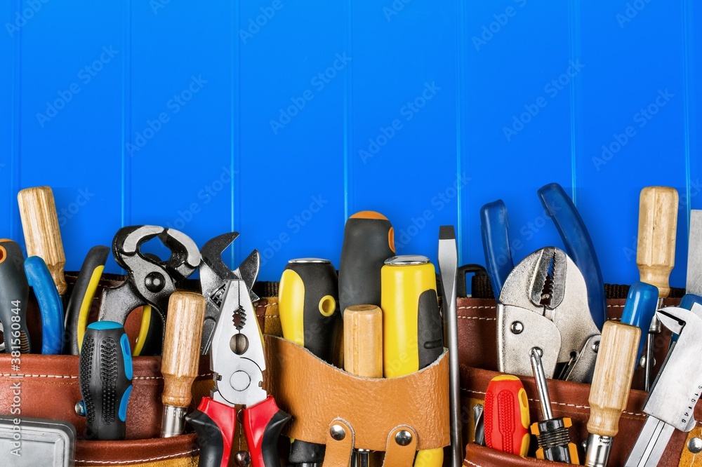 Tool belt with tools on wooden background