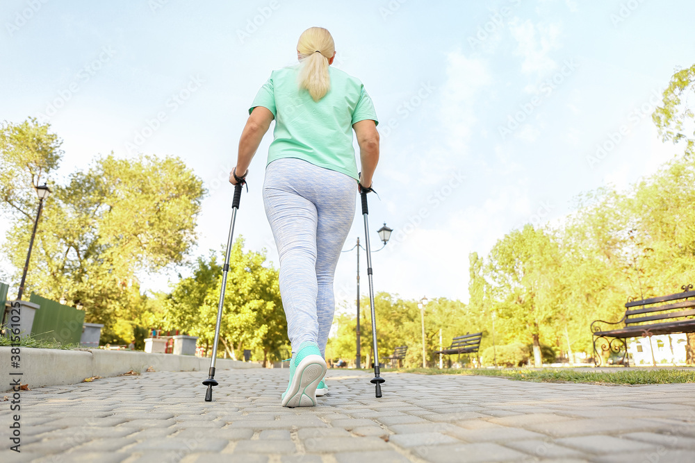 Mature woman with walking poles outdoors