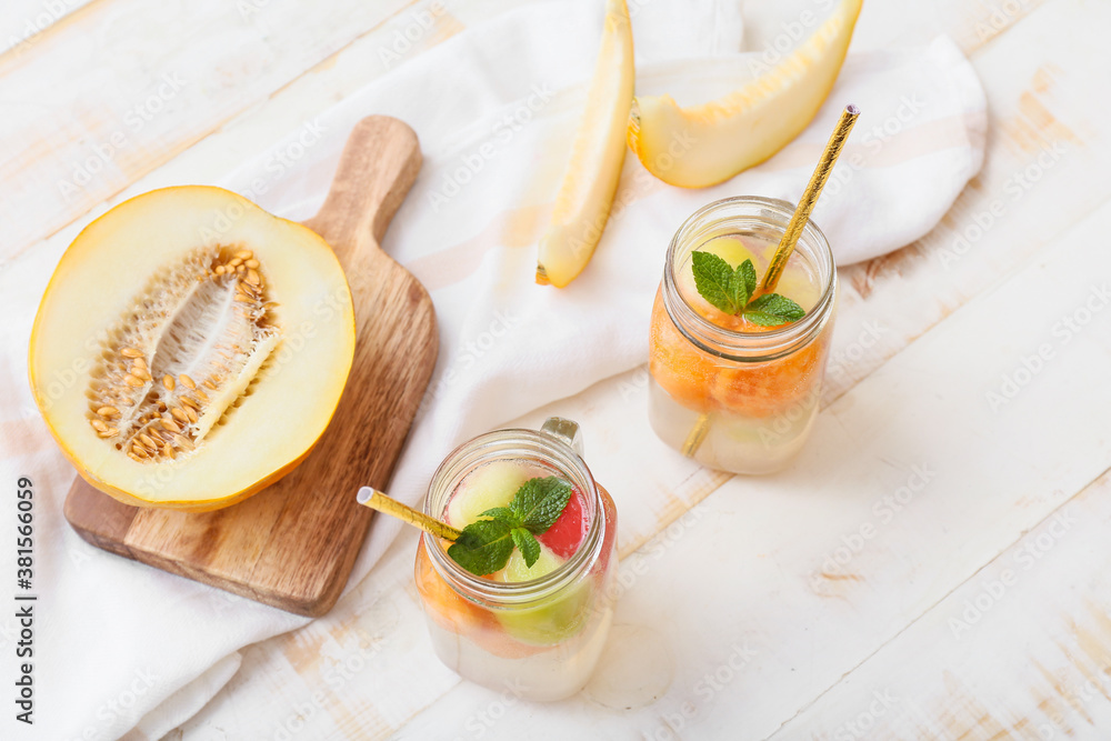 Mason jars of cold melon cocktail on table