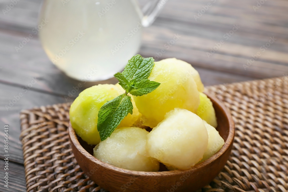 Bowl with tasty melon balls on table