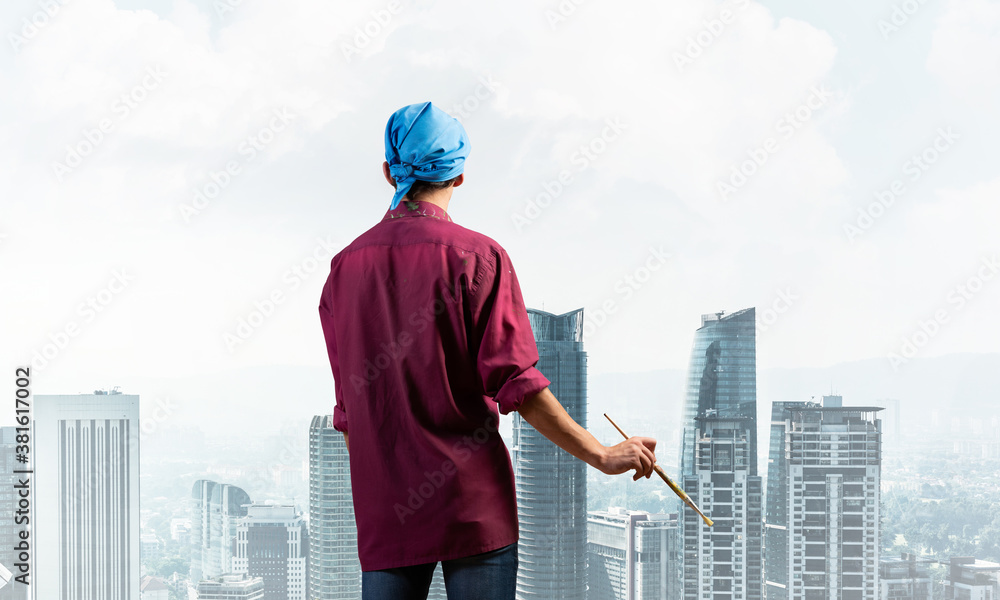 Young male artist holding paintbrush