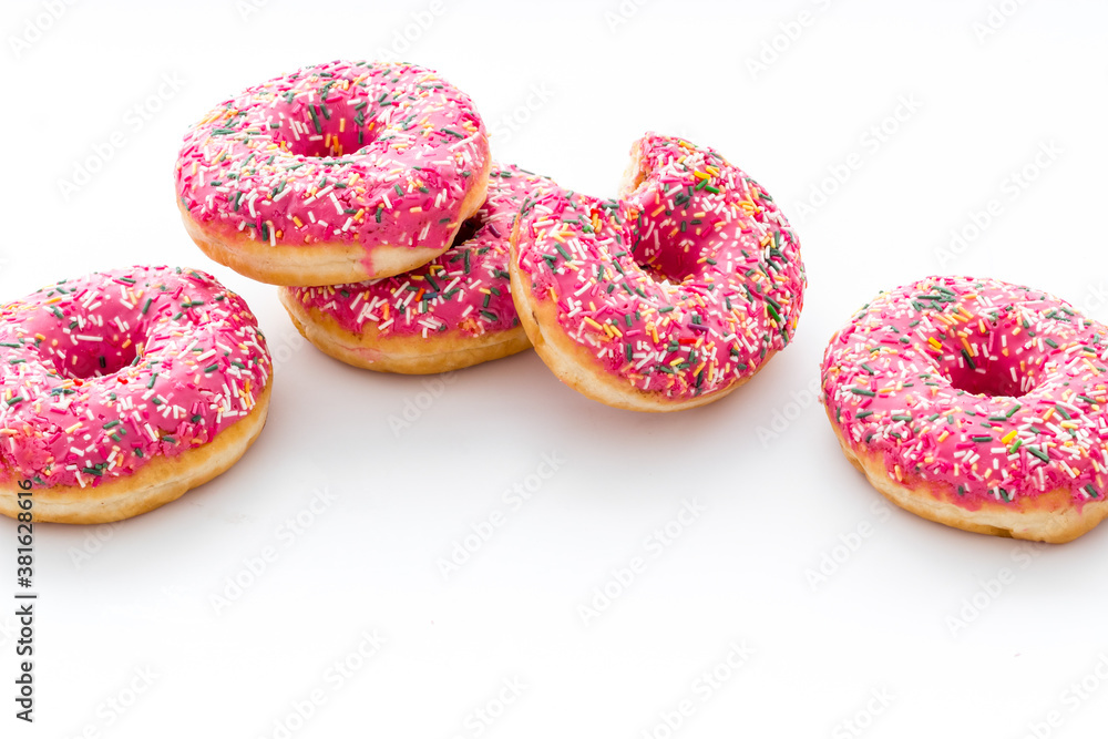 Pink berry donuts close up. Glazed and sprinkles bakery