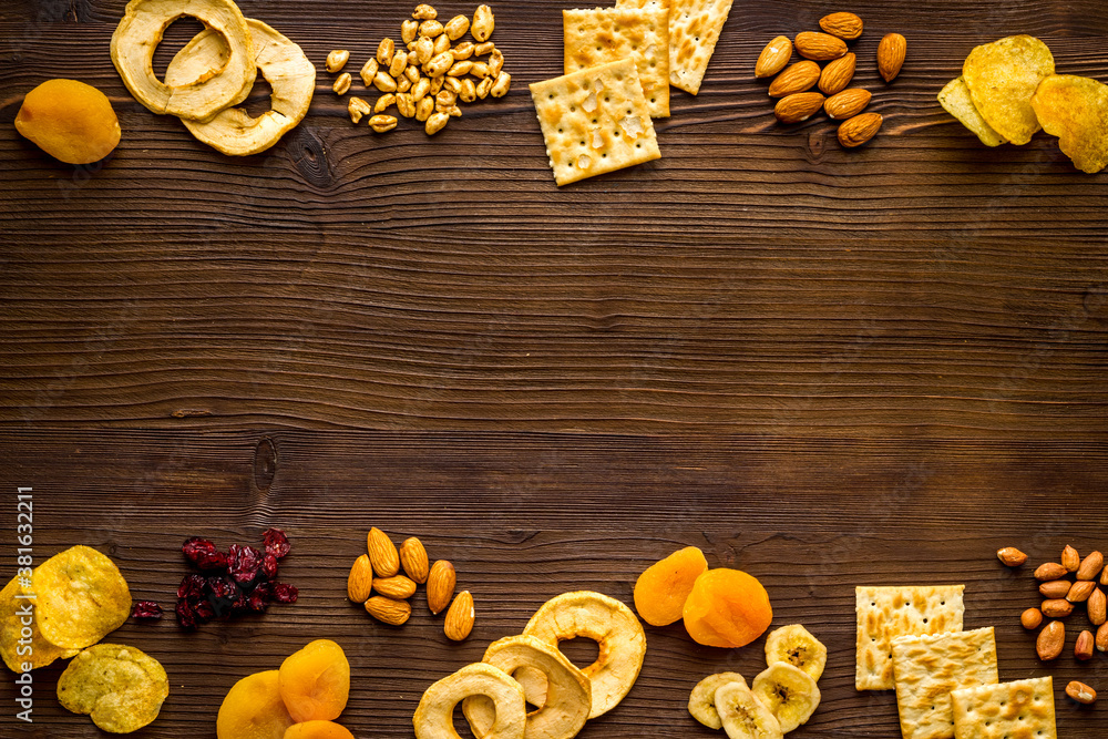 Snacks mix frame top view. Nuts and dried fruits with crackers, copy space