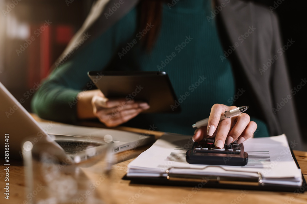 Businessman hands working with finances about cost and calculator and laptop with tablet, smartphone