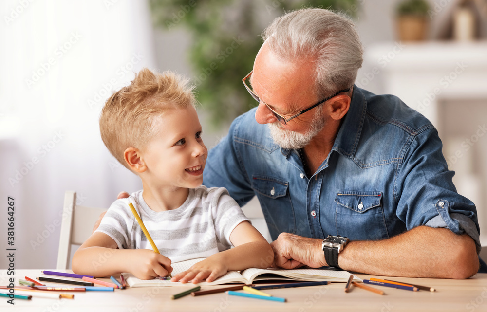 Cheerful boy drawing with grandfather.