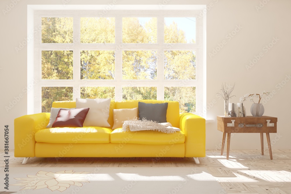 Stylish room in white color with sofa and autumn landscape in window. Scandinavian interior design. 