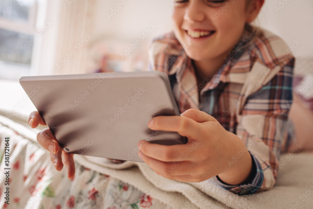 Girl using digital tablet in bed