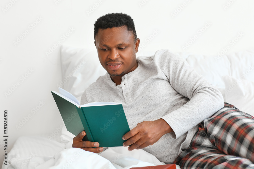 African-American man reading book at home