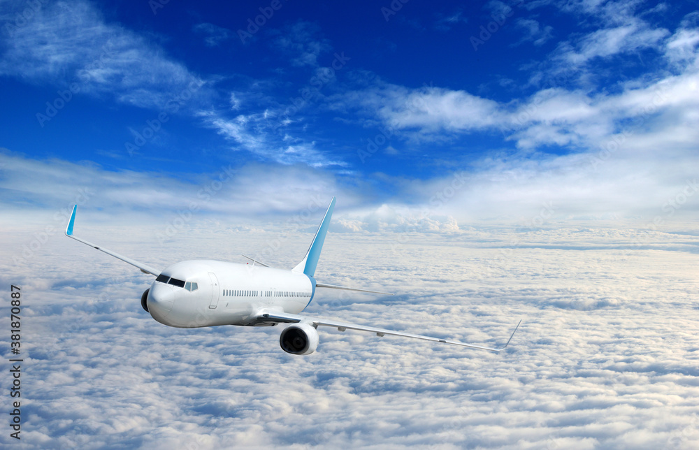 White airplane flying above clouds in the sky