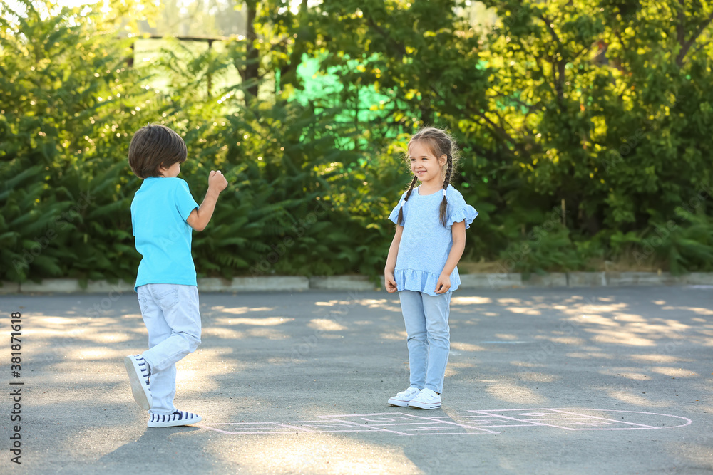 Little children playing hopscotch outdoors