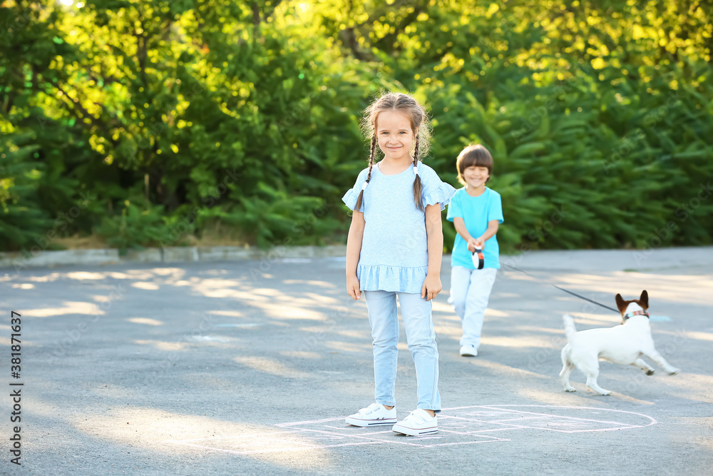 Little girl playing hopscotch outdoors