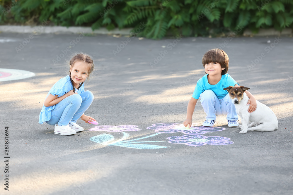 Little children drawing with chalk on asphalt