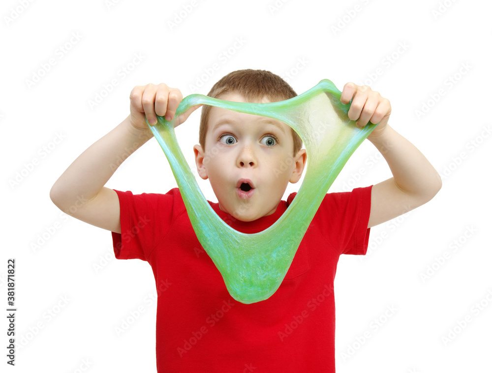 Boy stretches slime toy in hands and looks