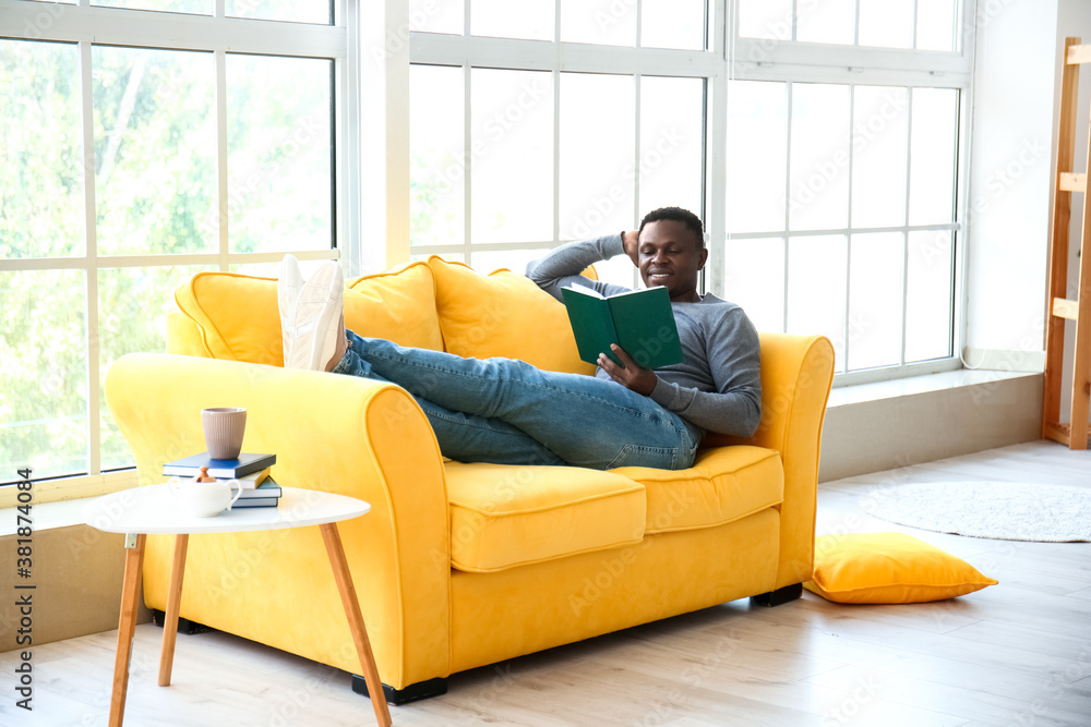 African-American man reading book at home