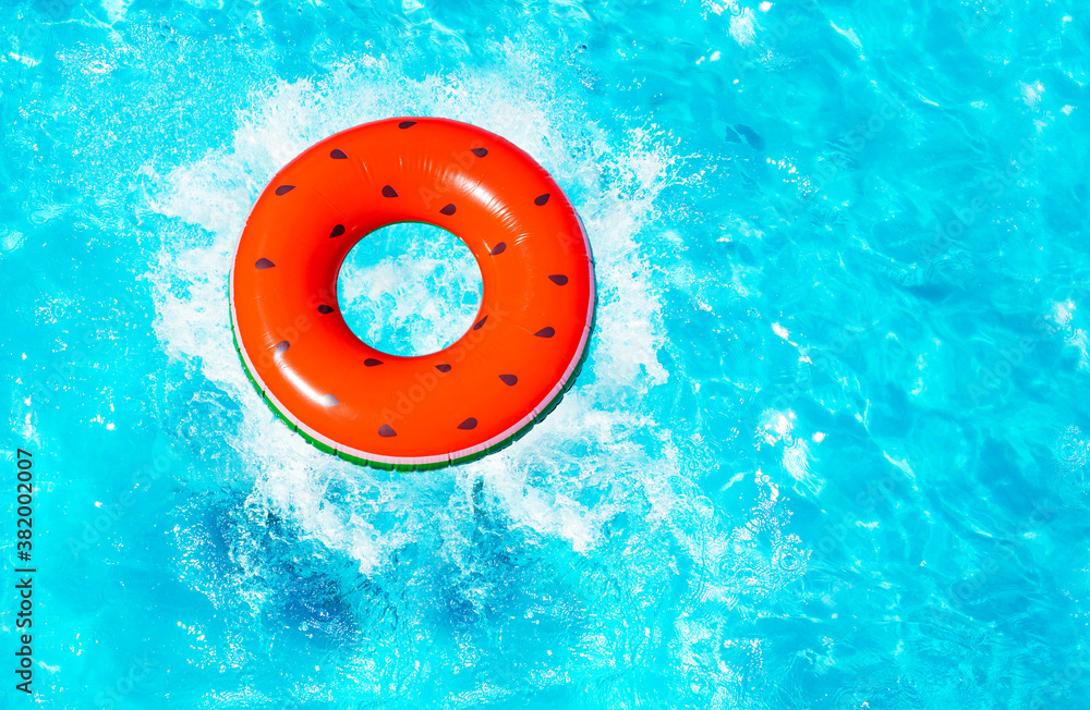 Inflatable red watermelon with seeds buoy splash fall into the swimming pool view from above