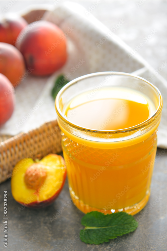 Glass of fresh peach juice on table