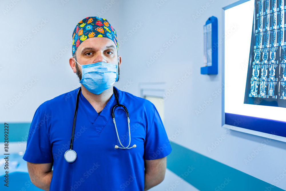 Doctor standing in office with x ray on the background. Medical male portrait. Medical concept. Hori