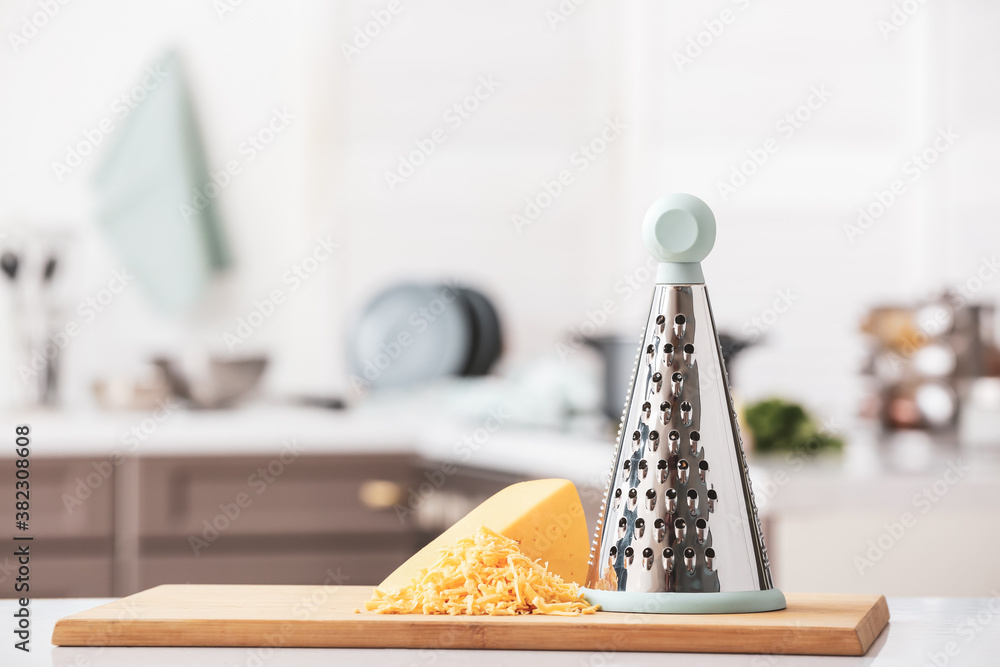 Metal grater and cheese on kitchen table