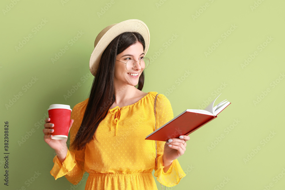 Beautiful young woman with book and coffee on color background