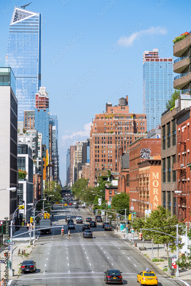 Manhattan street where you can see pedestrians and cars in an evening light