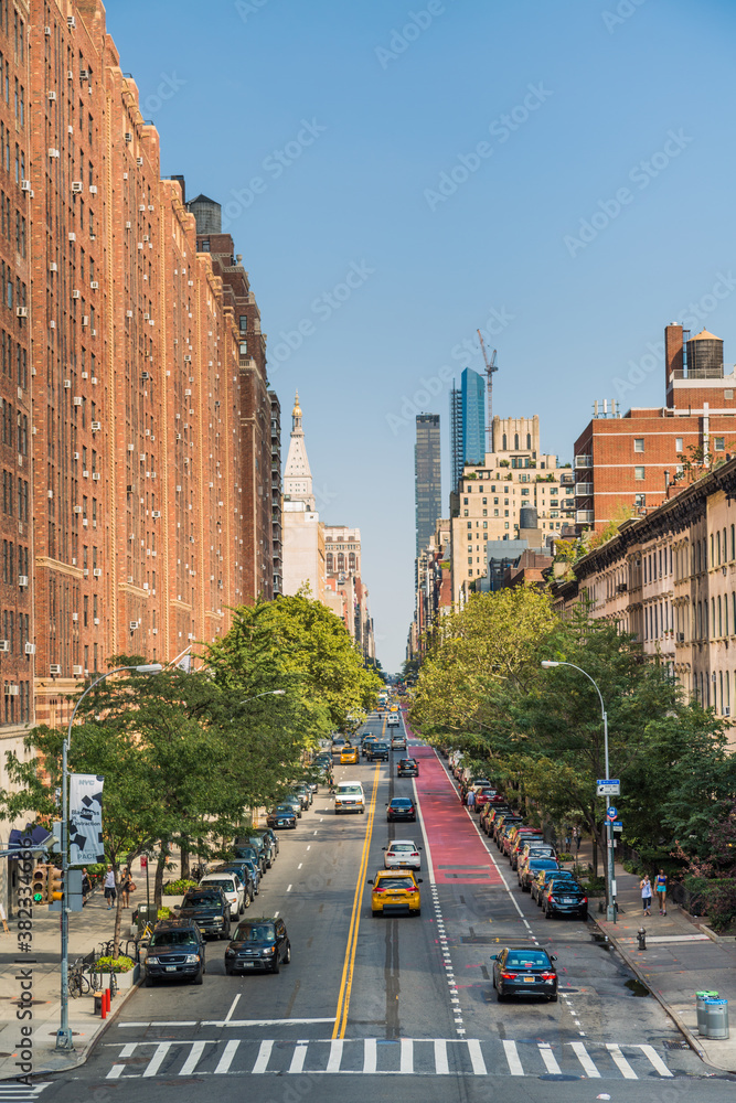 Manhattan street where you can see pedestrians and cars in an evening light