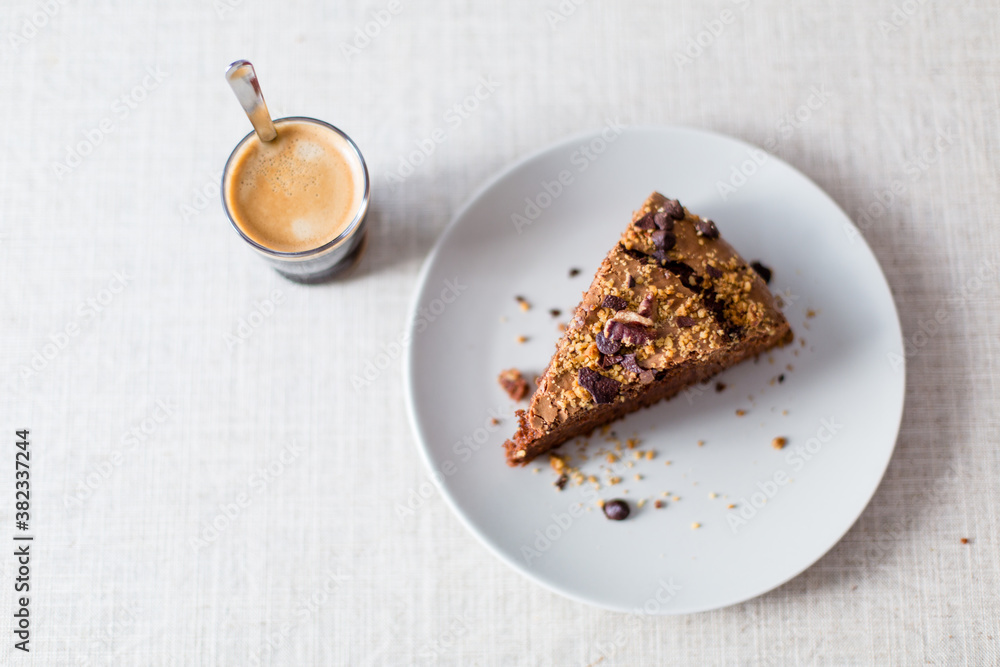 piece of homemade chocolate cake with nuts and espresso ready to take