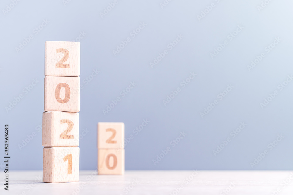 2021 New Year abstract design concept - Number wood block cubes isolated on wooden table and light m