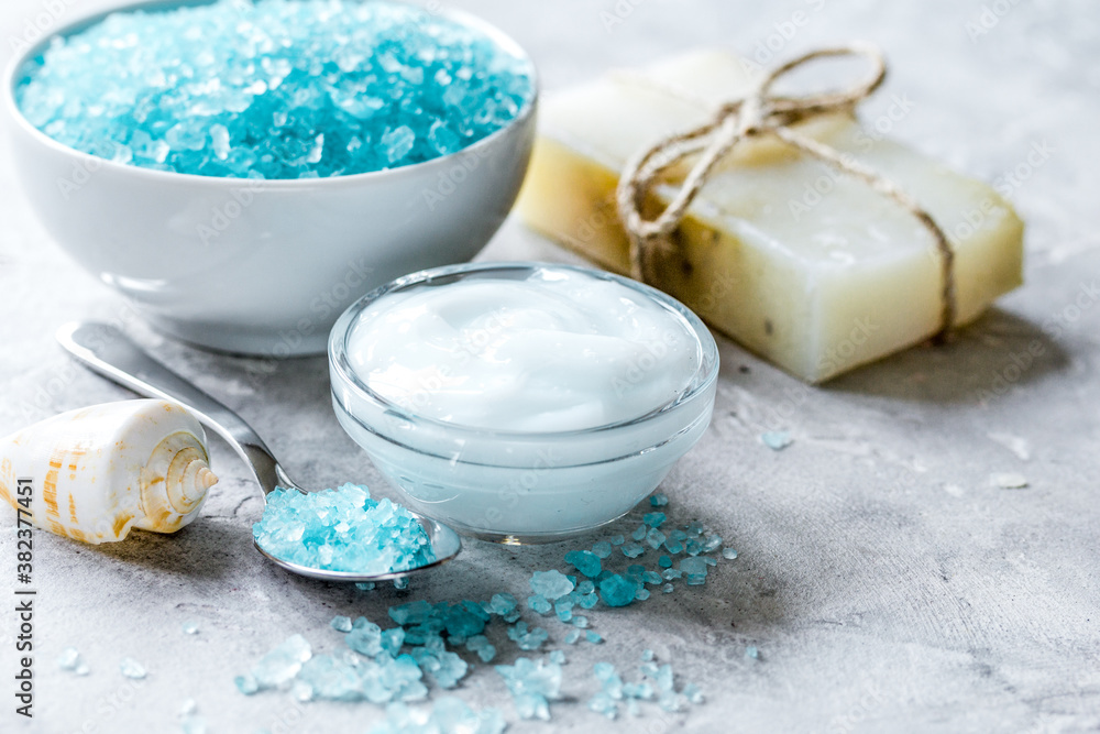 blue set for bath with salt and shells on stone table background