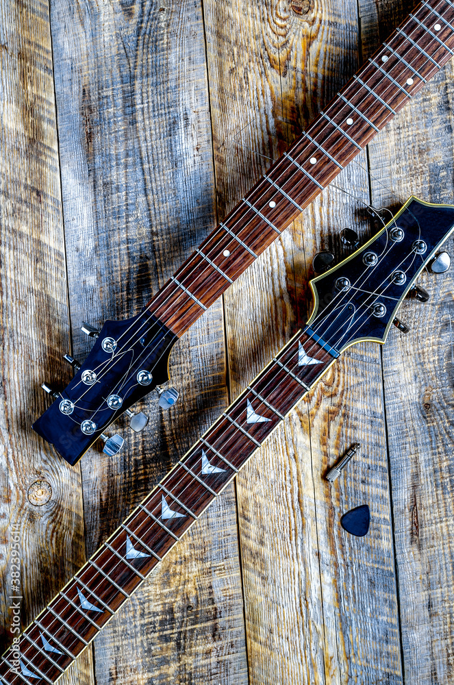 Two electric guitar bodies on wooden board background.