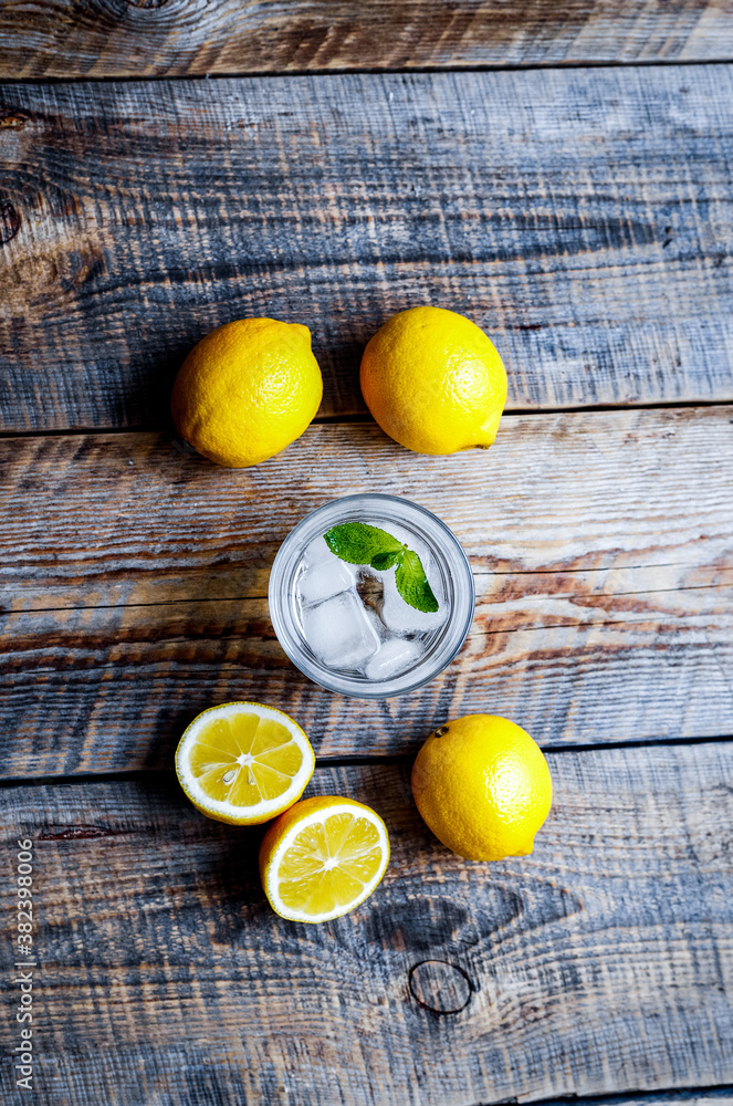 Lemonade with fresh lemon and mint on wooden background