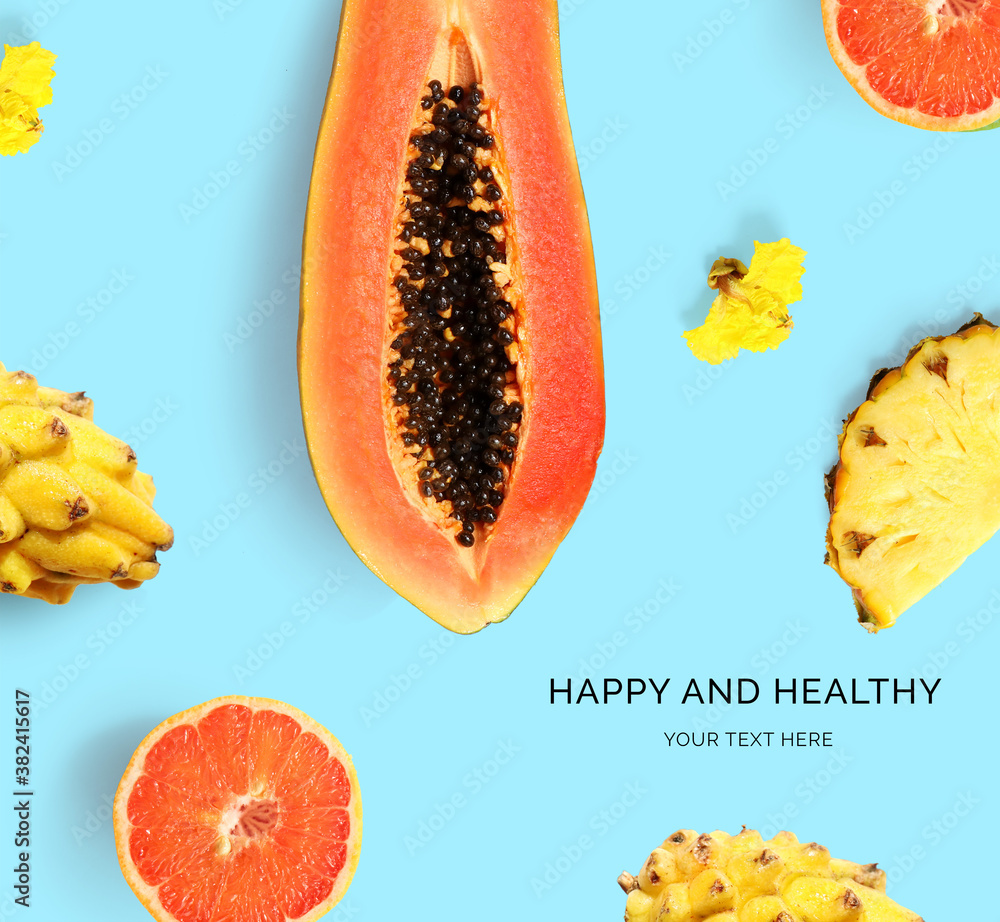 Creative layout made of papaya, pitaya, grapefruit and pineapple on the blue background. Flat lay. F