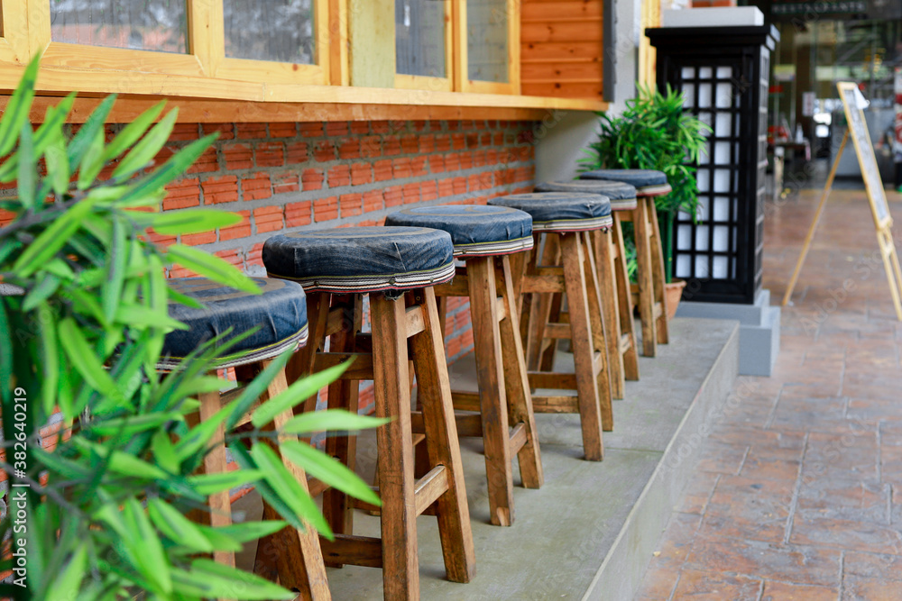 The bar stools are made of wood arranged in front of the restaurant. The unclear part is made to mak