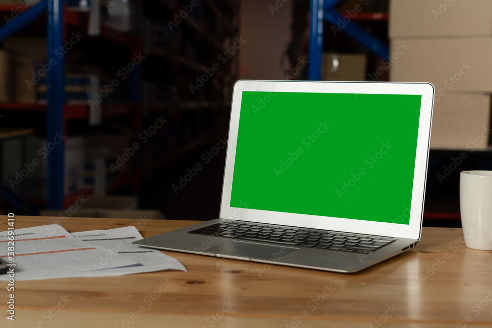 Computer with green screen display in warehouse storage room . Delivery and transportation software 