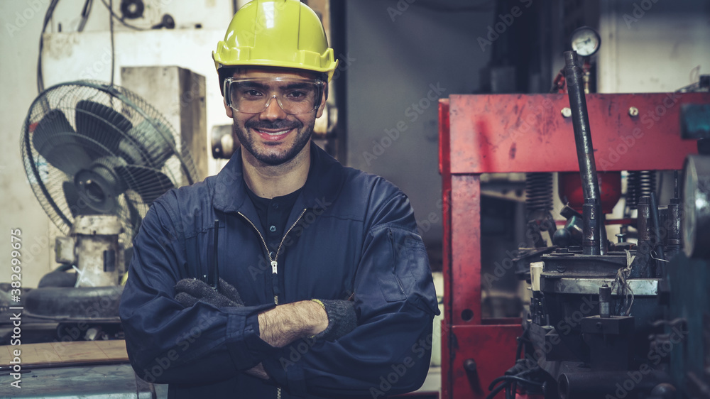 Young factory worker or engineer close up portrait in factory . Industry and engineering concept .