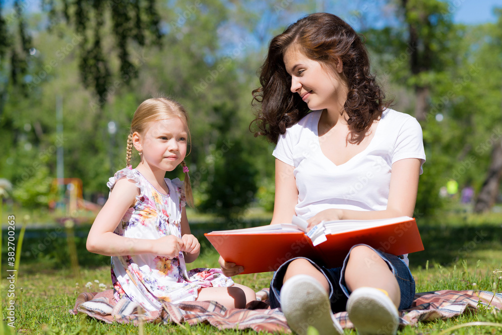 girl and a young woman reading a book together