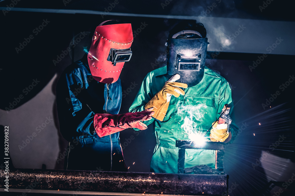 Metal welding steel works using electric arc welding machine to weld steel at factory. Metalwork man