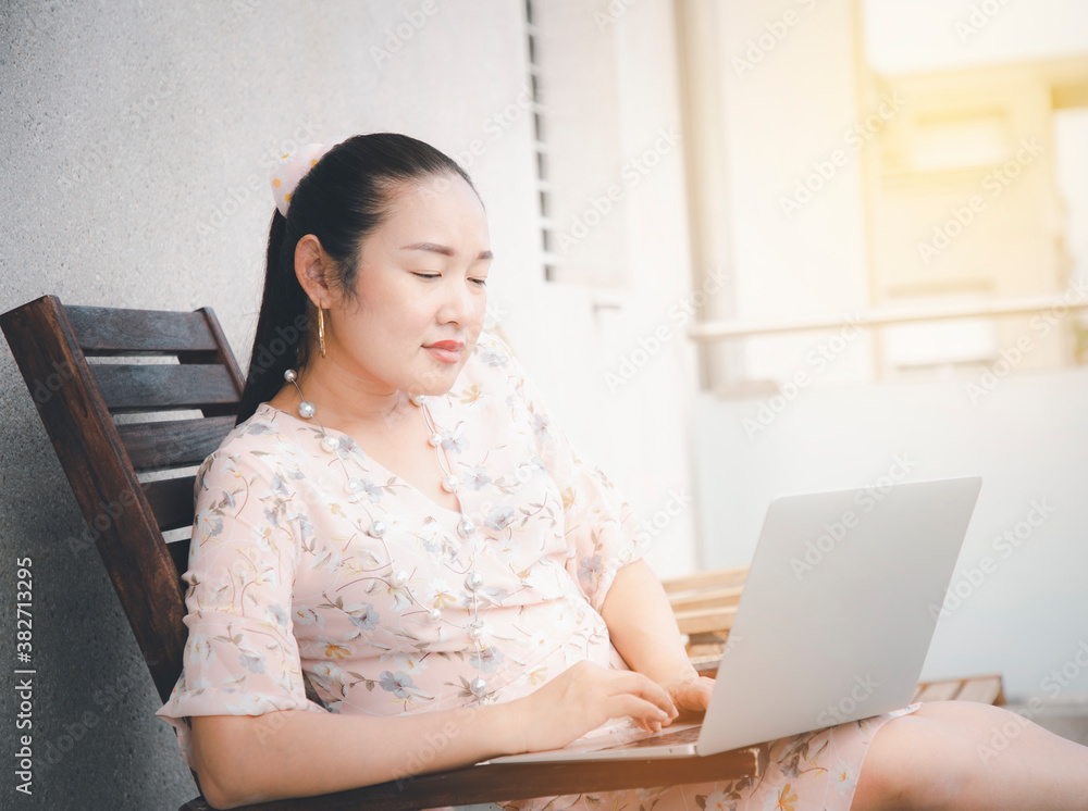 Asian woman using a laptop communicates on the internet with the customer or buy order online at hom