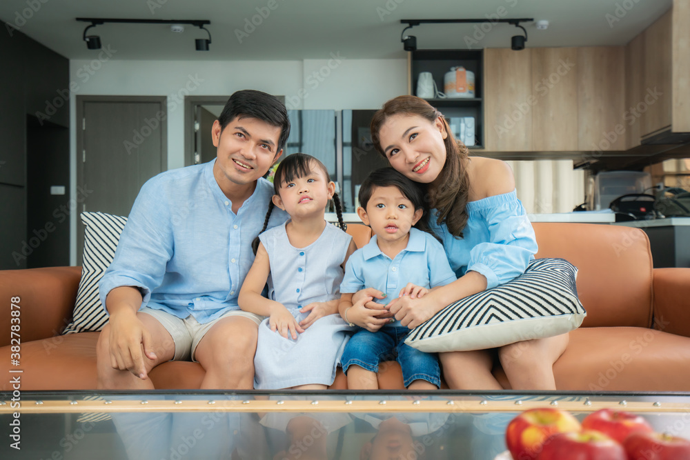 Asian happy family sitting and watching television in living room at home and spent quality time tog