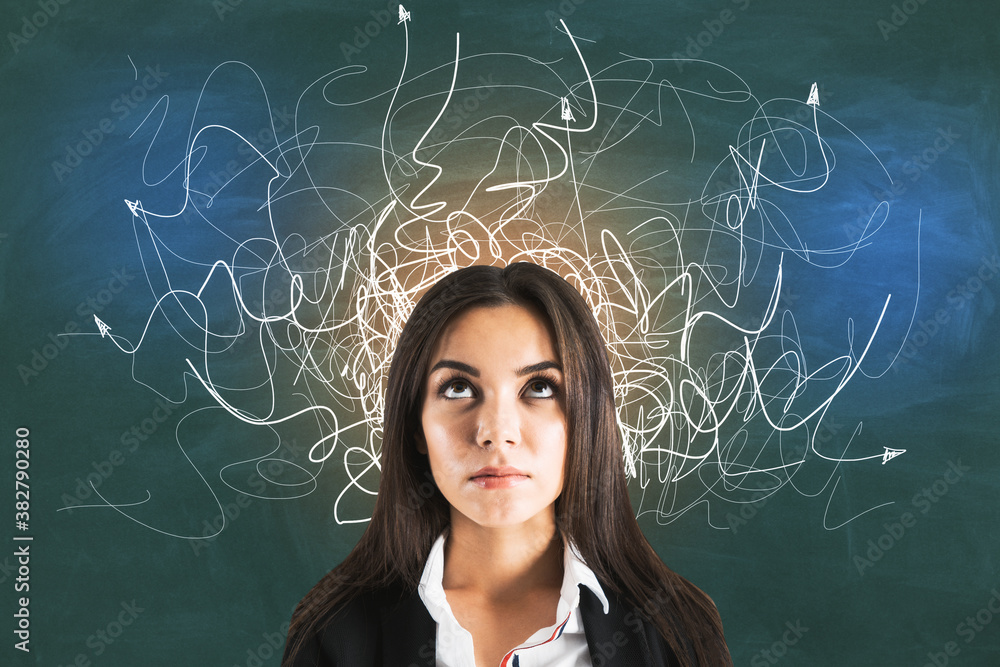 Businesswoman in suit with drawing arrows over her head on blackboard.