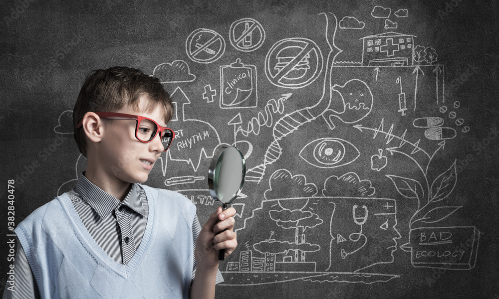 Curious school boy with magnifier