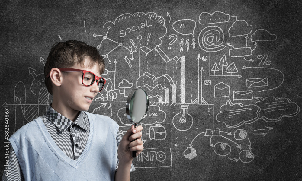 Curious school boy with magnifier