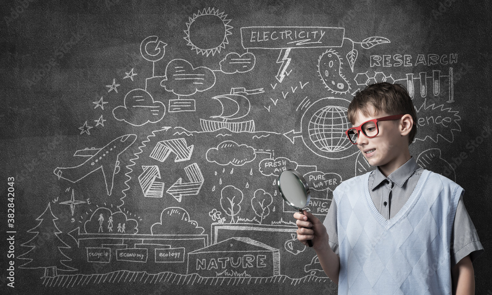 Curious school boy with magnifier