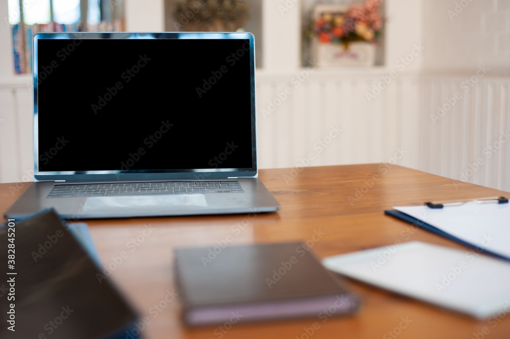 A laptop with a blank screen on the desk in the office.